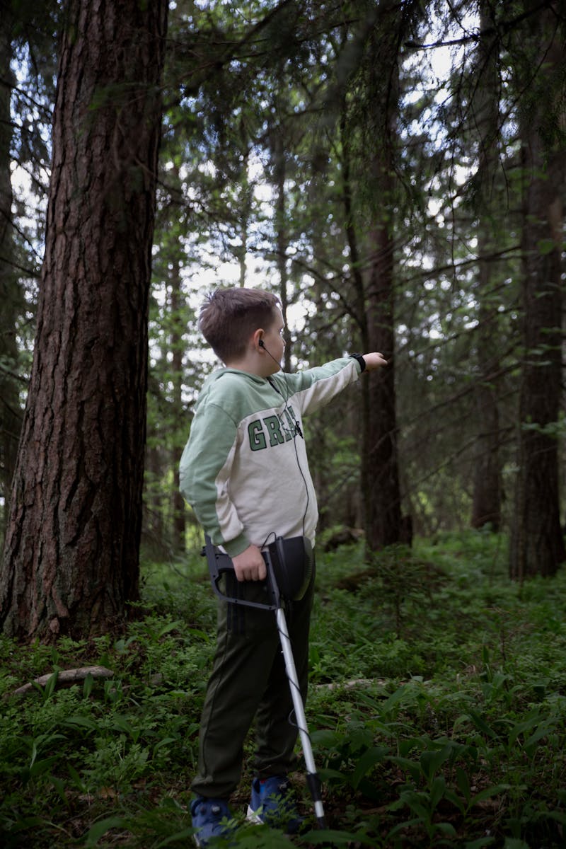 Boy with Metal Detector in Forest